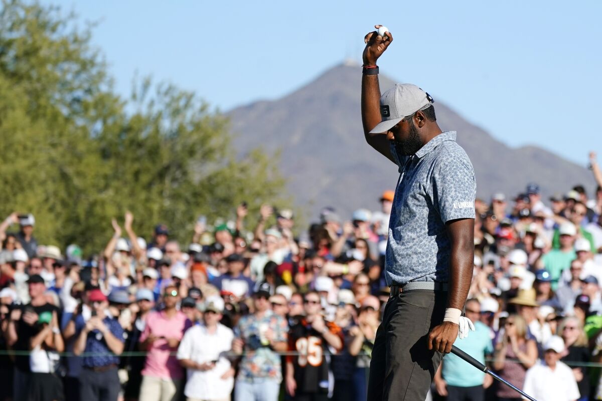 Sahith Theegala acknowledges the cheering crowd after putting out on the 18th green during the final round of the Phoenix Open golf tournament Sunday, Feb. 13, 2022, in Scottsdale, Ariz. (AP Photo/Ross D. Franklin)