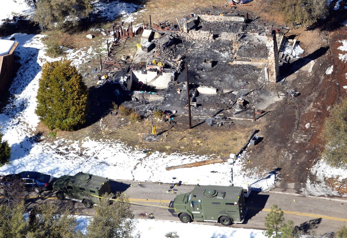 Law enforcement authorities investigate the burn-out cabin on Wednesday where accused quadruple-murder suspect Christopher Dorner was believed to have died after barricading himself inside.