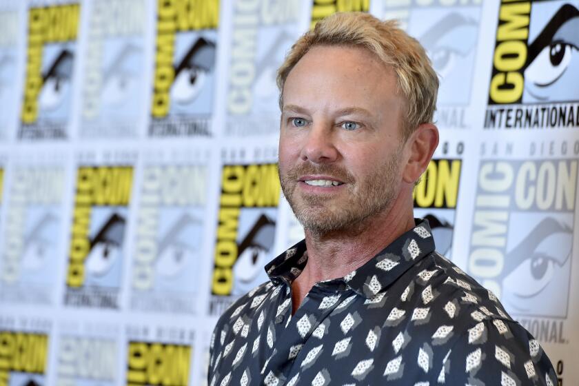 Ian Ziering poses against a Comic-Con backdrop