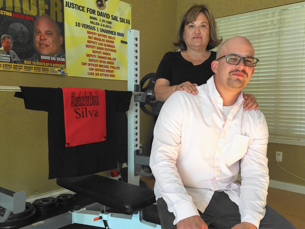 Chris Silva and his mother, Merri Silva, sit in front of a poster of David Silva, who died in an altercation with Kern County sheriff's deputies three years ago.