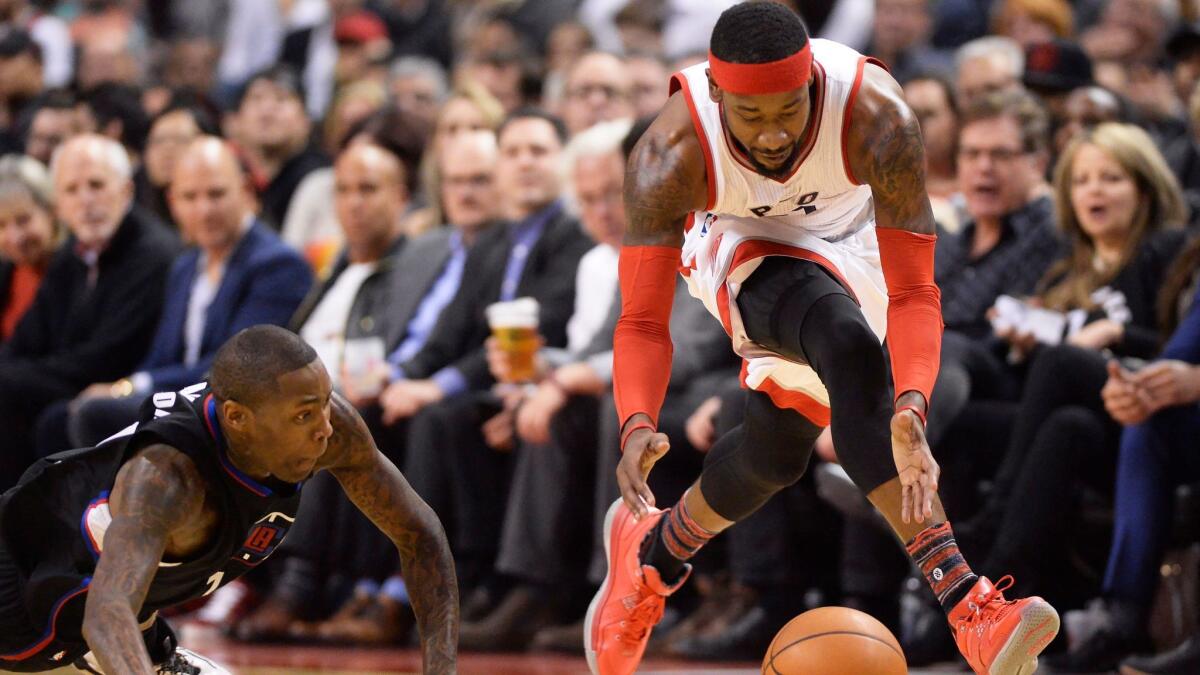 Toronto forward Terrence Ross picks up a loose ball next to diving Clippers guard Jamal Crawford on Monday.