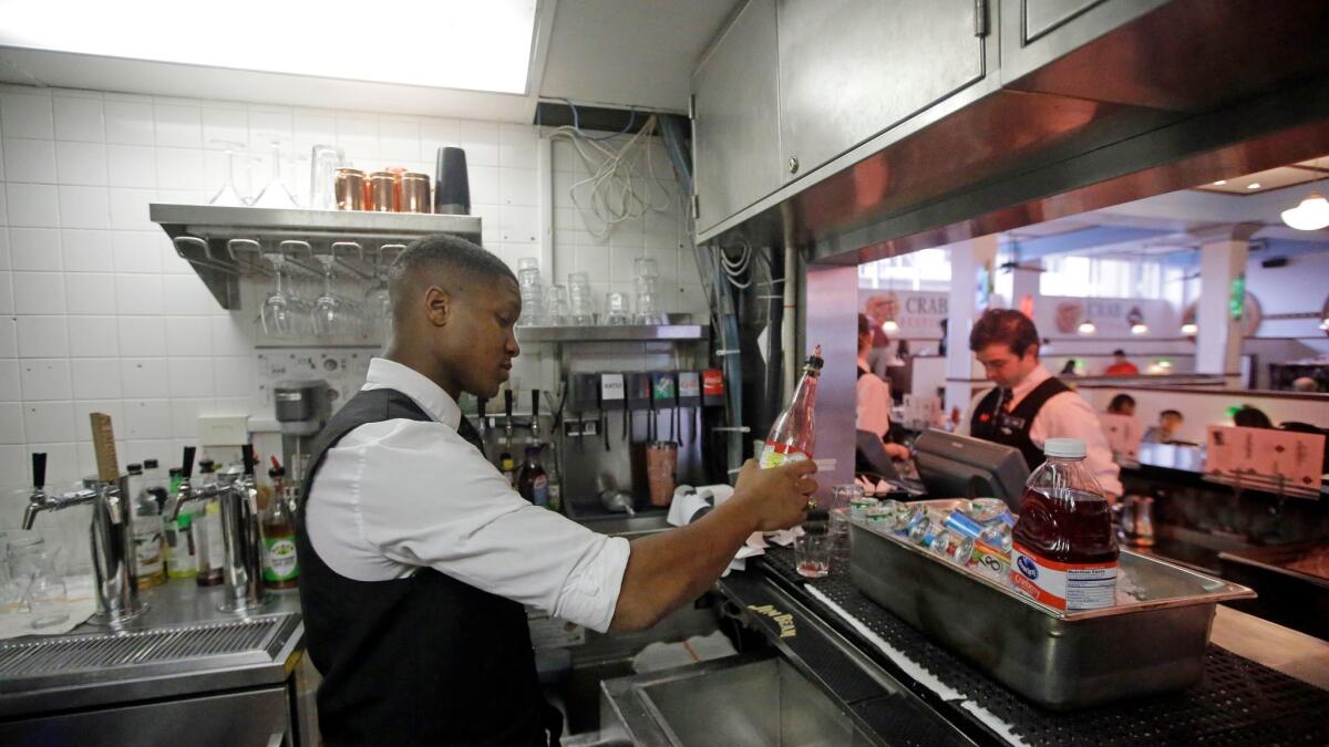 Colton Prestwich works behind a so-called Zion curtain, a barrier that had been required in Utah bars and restaurants to shield patrons from workers preparing alcoholic drinks.