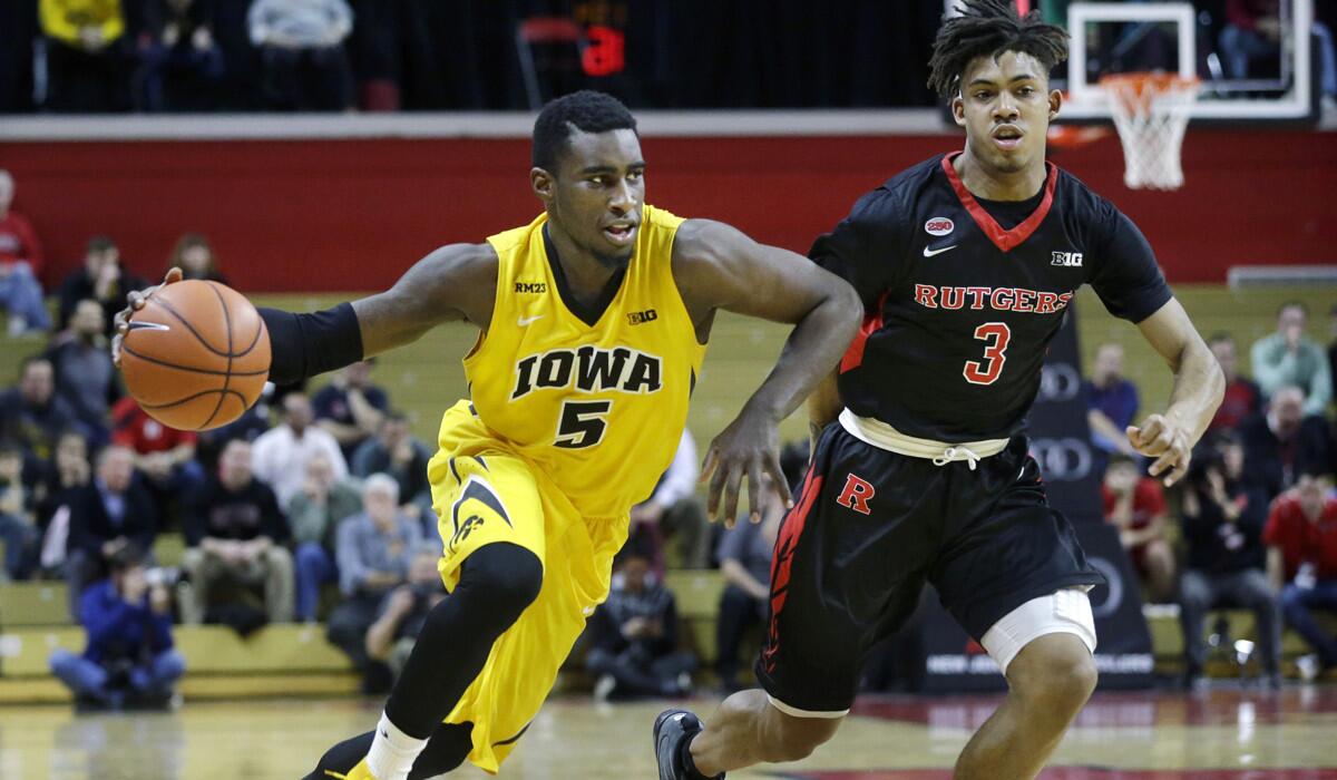 Iowa guard Isaiah Moss (5) dribbles the ball past Rutgers guard Corey Sanders (3) during the second half on Thursday.