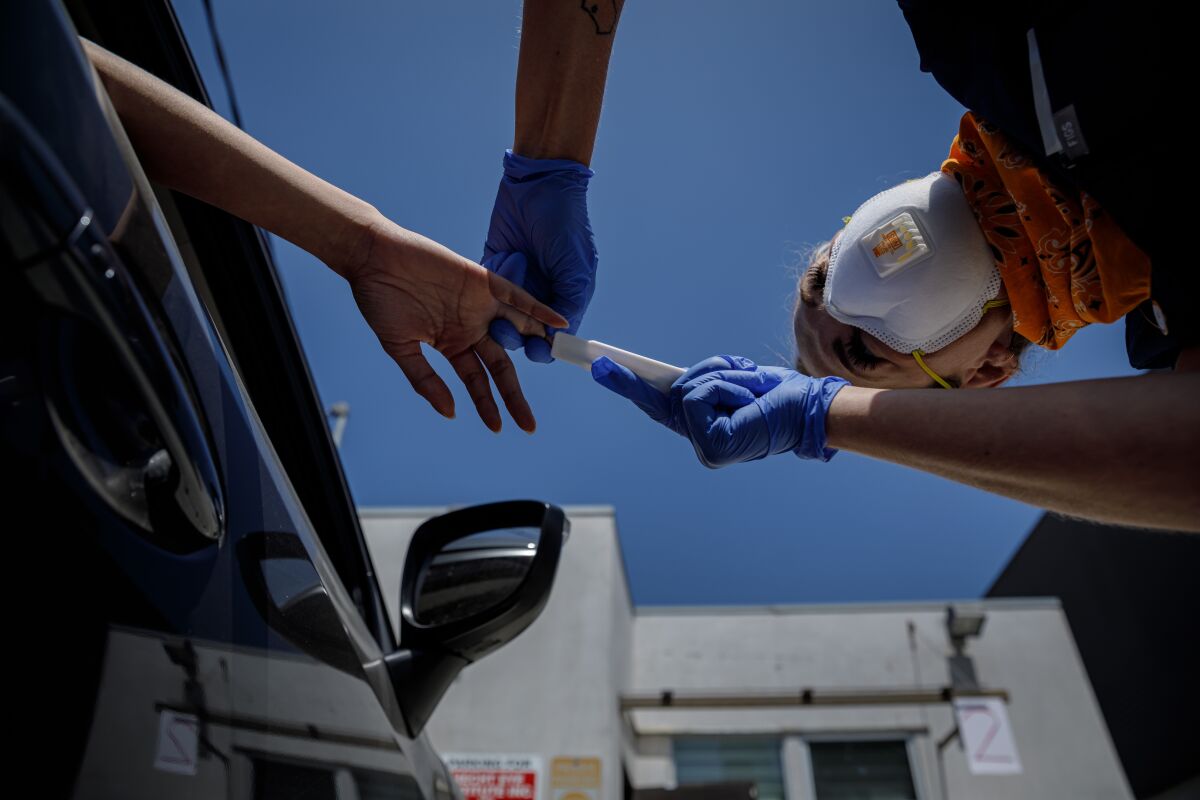 A woman is tested for coronavirus antibodies at a drive-thru testing site