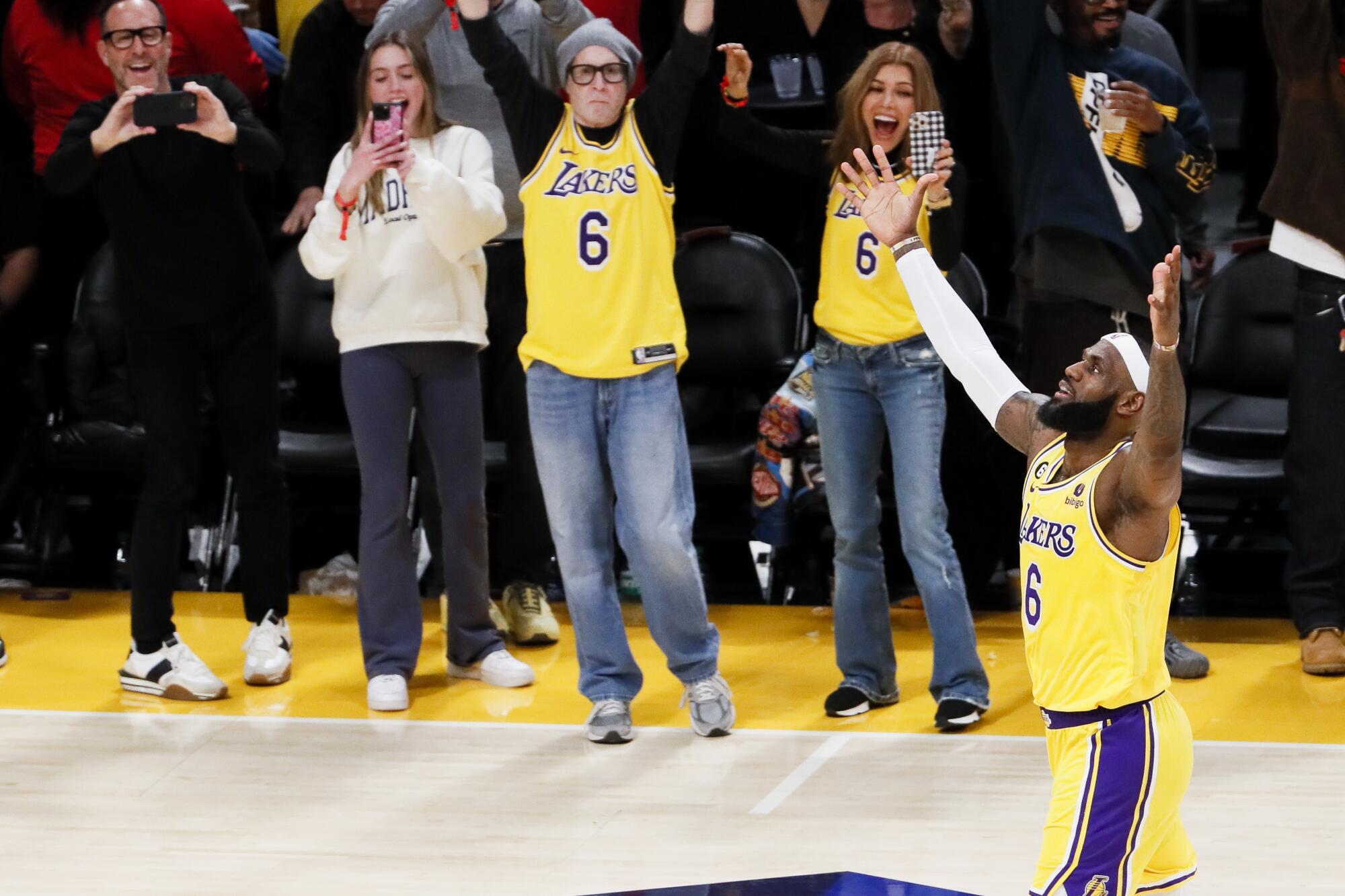 Lakers forward LeBron James throws his arms in the air after making the basket that gave him the NBA's all-time scoring lead.