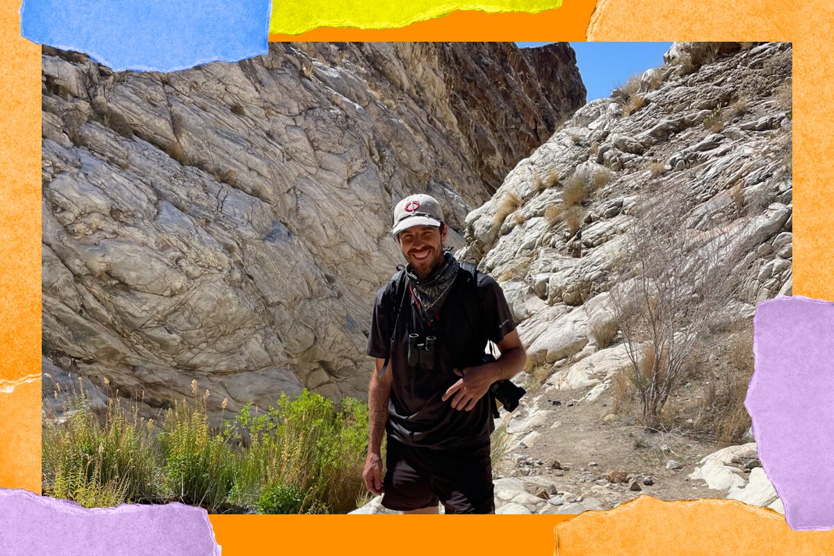 Josh Jackson stands with large boulders behind him at Surprise Canyon Wilderness.
