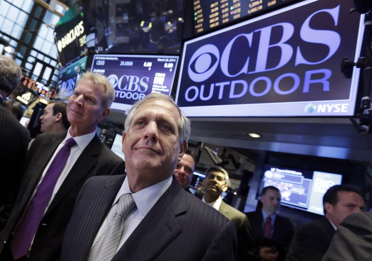 CBS President and CEO Leslie Moonves, center, and CBS Outdoor Americas Inc. CEO Jeremy Male, left, stop at the post on the floor of the New York Stock Exchange, before CBS Outdoor's IPO on Friday.