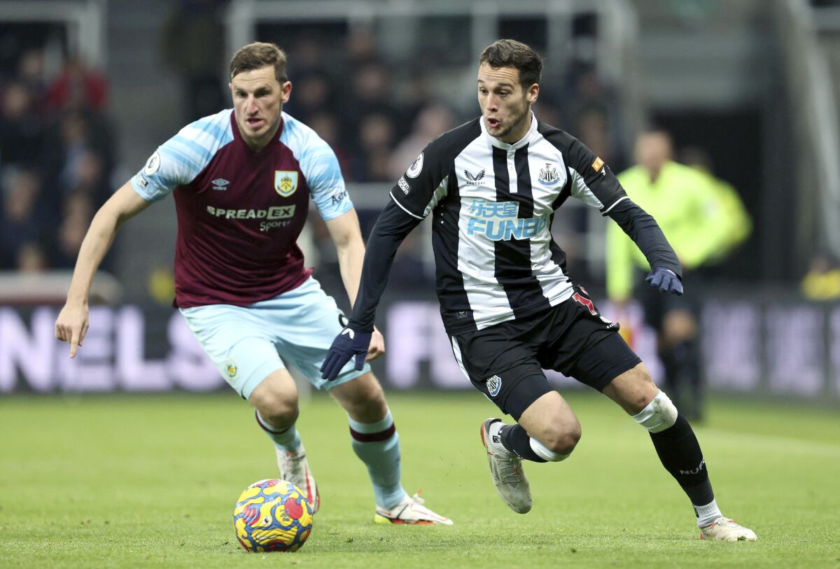 Burnley's Chris Wood, left and Newcastle United's Javier Manquillo in action, during the English Premier League soccer match between Newcastle United and Burnley, at St. James' Park, in Newcastle upon Tyne, England, Saturday, Dec. 4, 2021. (Richard Sellers/PA via AP)
