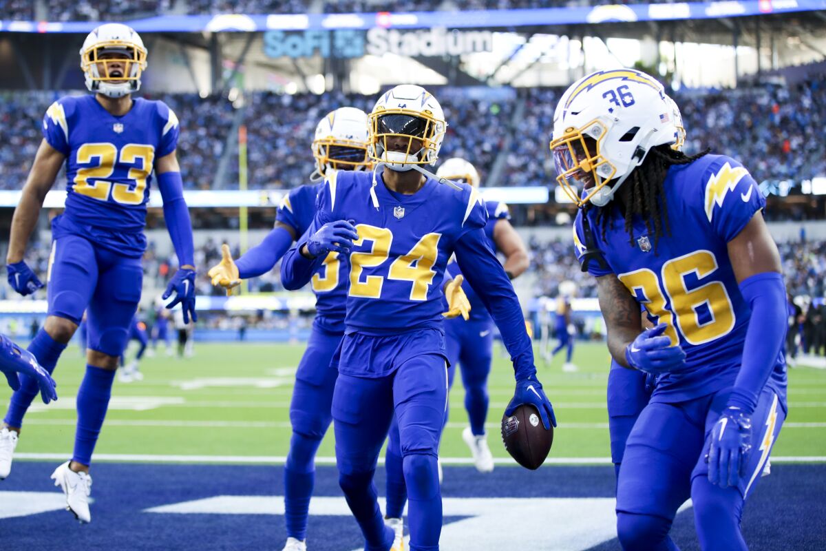 Nasir Adderley (24) celebrates his interception against the Titans with Chargers teammates. 