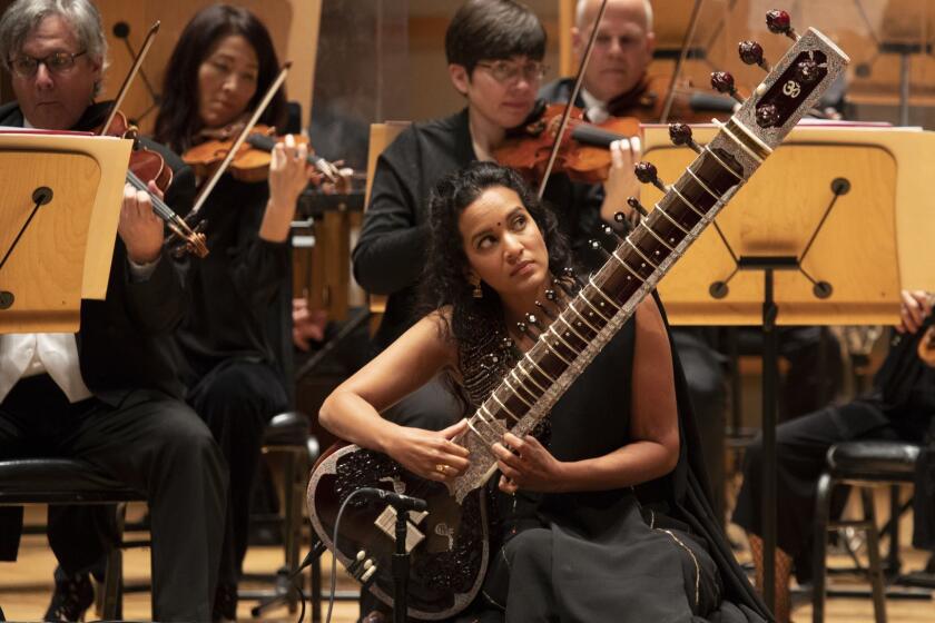 COSTA MESA, CALIF. -- THURSDAY, APRIL 12, 2018: Carl St. Clair conducts The Pacific Symphony and sitar soloist Anoushka Shankar, center, perform Sitar Concerto No. 3 during Glass & Shankar at the Renee and Henry Segerstrom Concert Hall in Costa Mesa, Calif., on April 12, 2018. (Allen J. Schaben / Los Angeles Times)