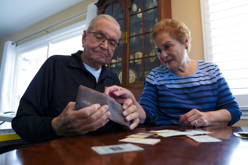 Paul Grisham and his wife, Carole Salazar, examine the recently recovered wallet that he lost in Antarctica in 1968.  
