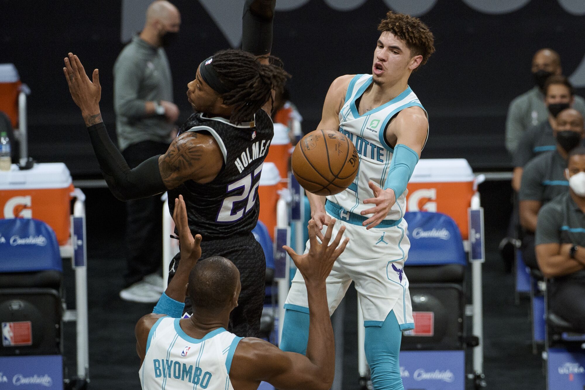 Hornets guard LaMelo Ball wraps a pass around Kings center Richaun Holmes.