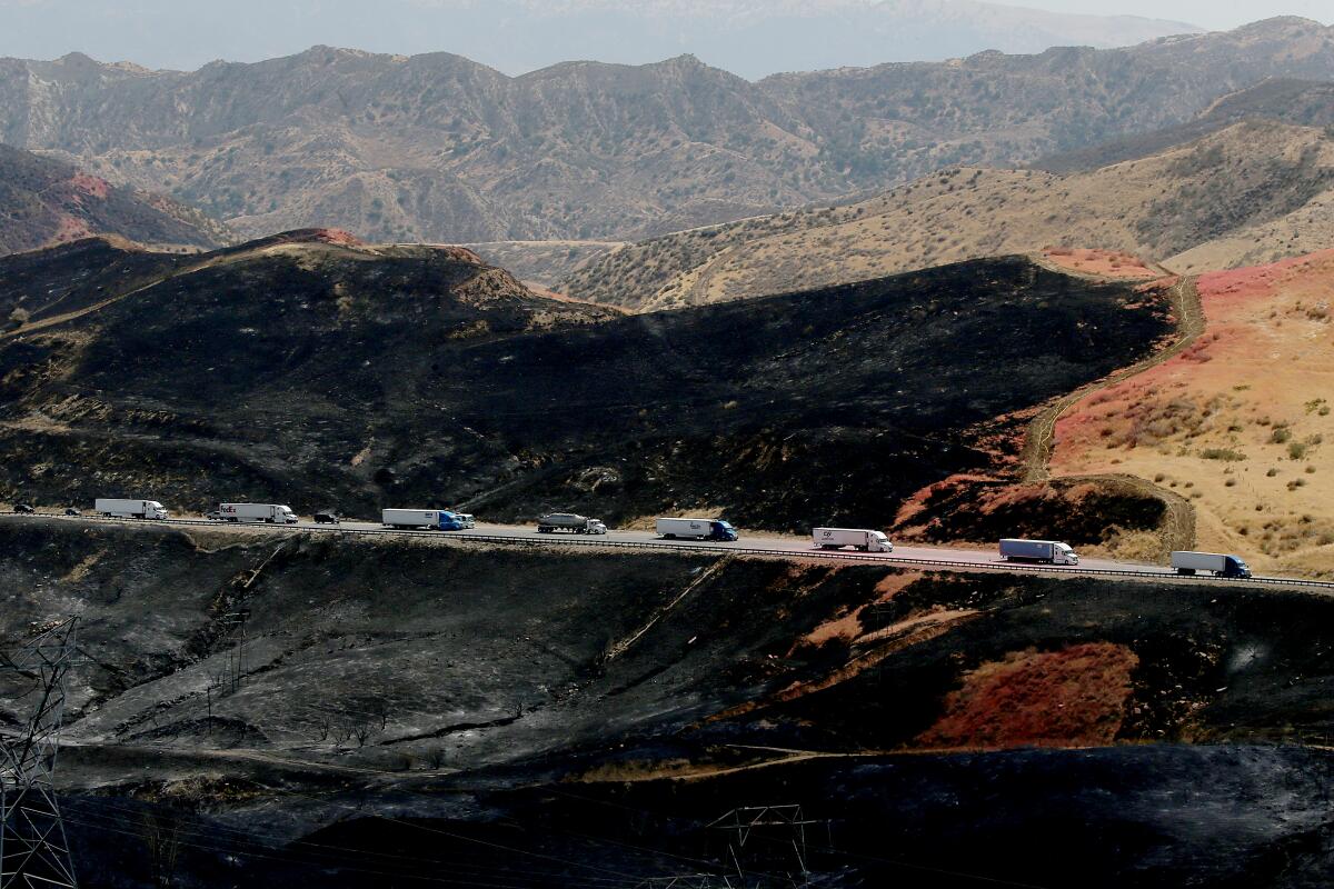 Traffic streams on an interstate through the burn zone of a fire.