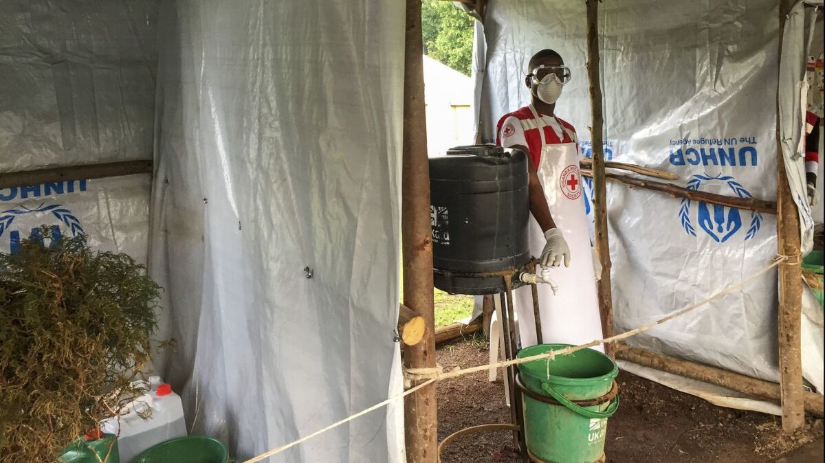 An Ebola screening checkpoint where people crossing from Congo to Uganda go through foot and hand washing with a chlorine solution and have their temperature taken.