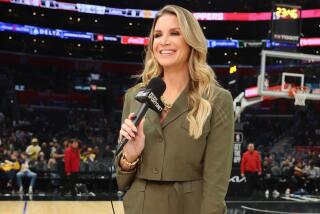 Allie Clifton holds a microphone and stands on the court as she reports on a Lakers-Clippers game at Crypto.com Arena.