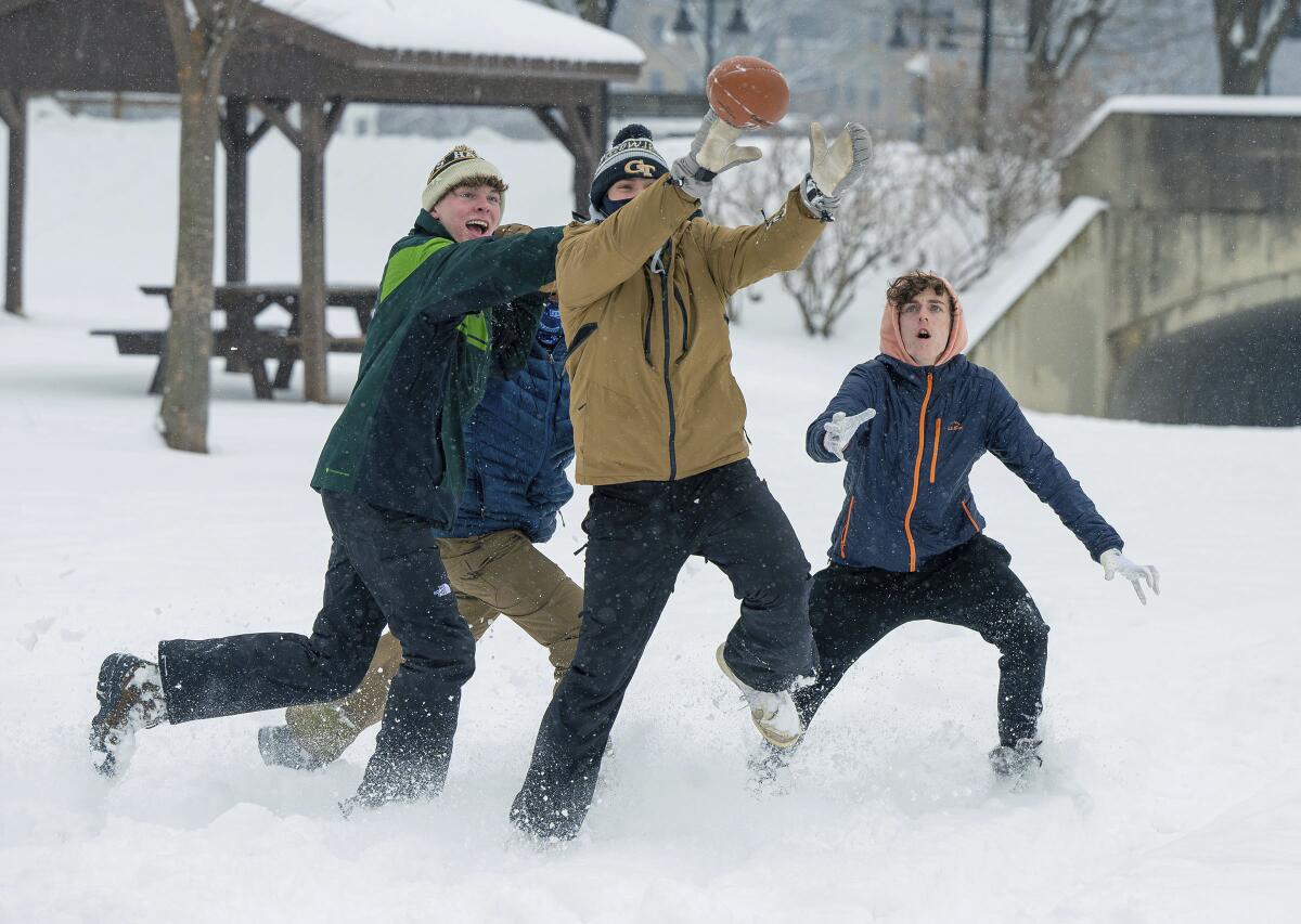 Kids play football in the snow.