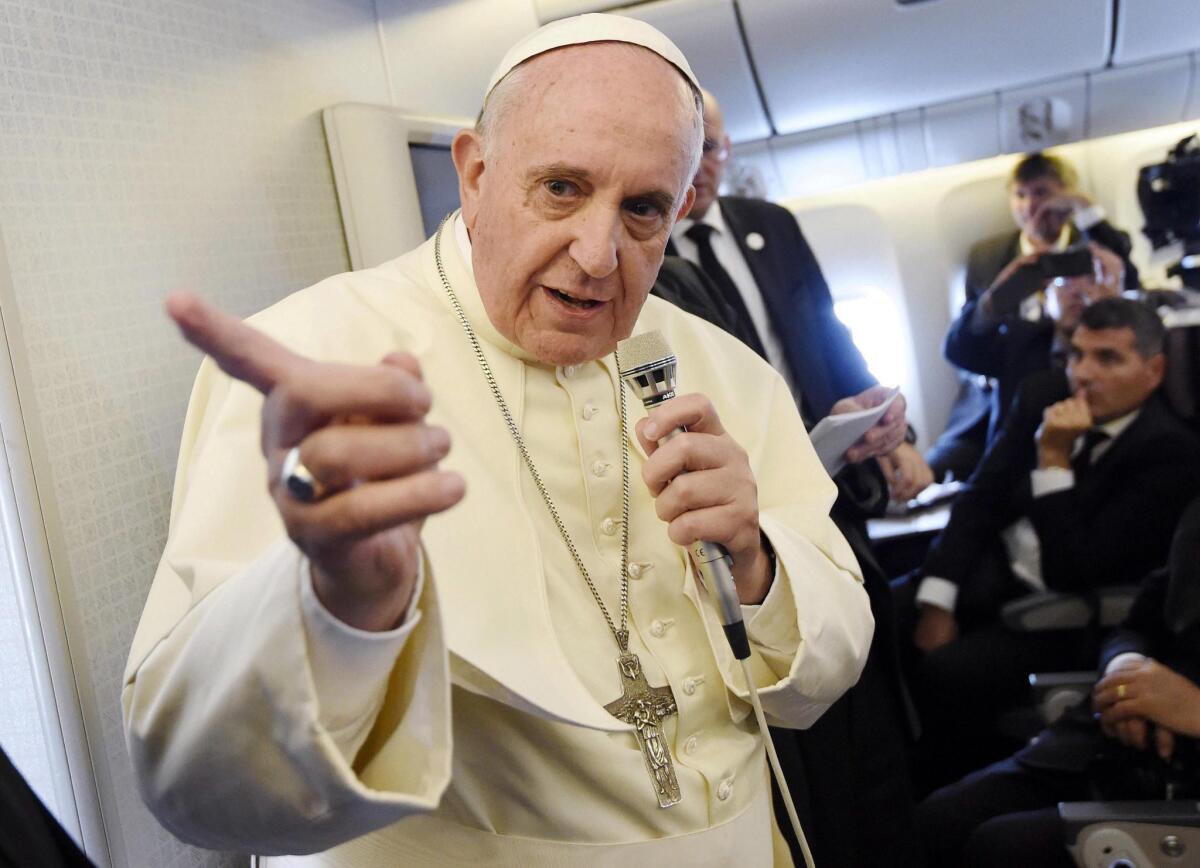 Pope Francis gestures while speaking to journalists aboard his plane as he returns to Rome from South Korea on Aug. 18.