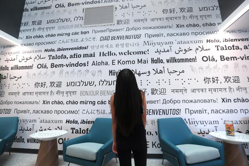 The new "Hello, welcome" wall, written in over a hundred diff languages, is shown during the Language Arts Complex Grand Opening Ceremony reception at Golden West College on Thursday.