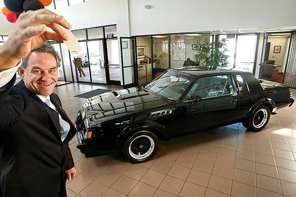Brad Willingham, co-owner of Boulevard Buick in Signal Hill, holds up the keys to a 1987 Buick GNX two-door coupe, shown on the showroom floor. This is the oldest car at a dealer to never be sold. The dealership tried to sell the car during the six-months after it first arrived but then decided to keep it as a collector's item.