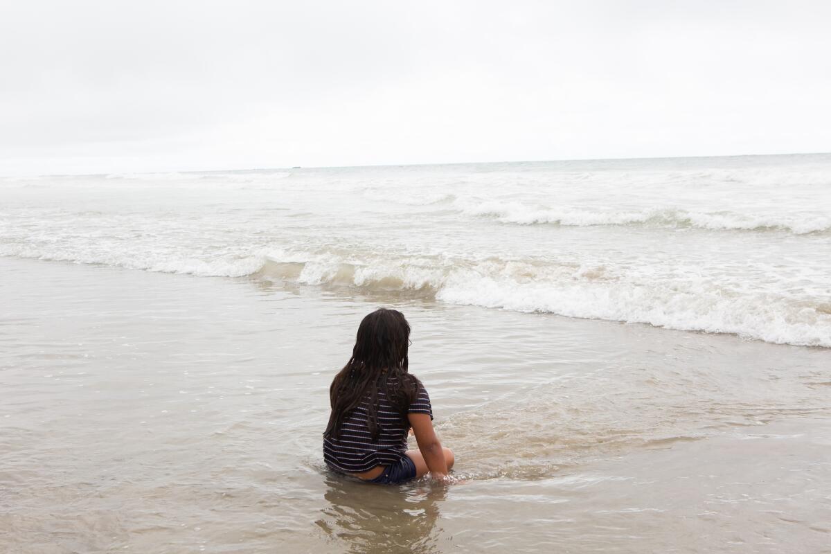 Jocelyn Corado, 8, waits for the next set of waves near the San Clemente Pier on Monday.