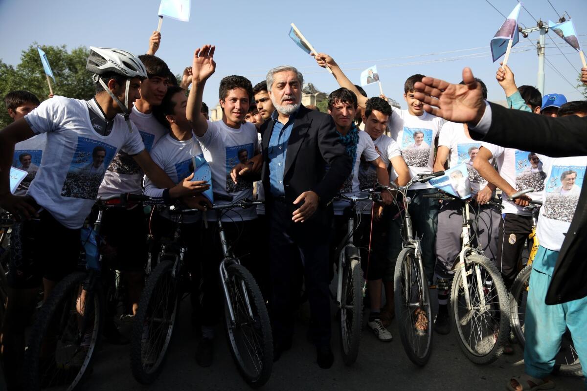 Afghan presidential candidate Abdullah Abdullah talks with supporters at a cycling event in Kabul shortly before two blasts struck his convoy.