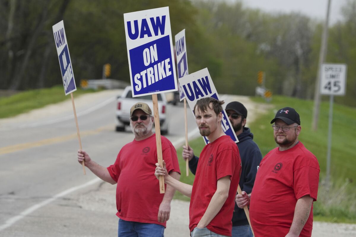 Members of United Auto Workers Local 807 carry picket signs after going on strike on Monday May 2, 2022, at a CNH plant in Burlington, Iowa. (John Loveretta/The Hawk Eye via AP)