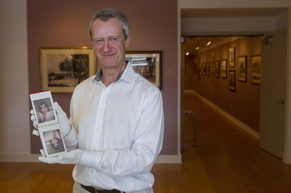 Malcolm Warner, the executive director of the Laguna Art Museum, holds a newly acquired photo album containing polaroid images of David Cassidy taken by Andy Warhol.