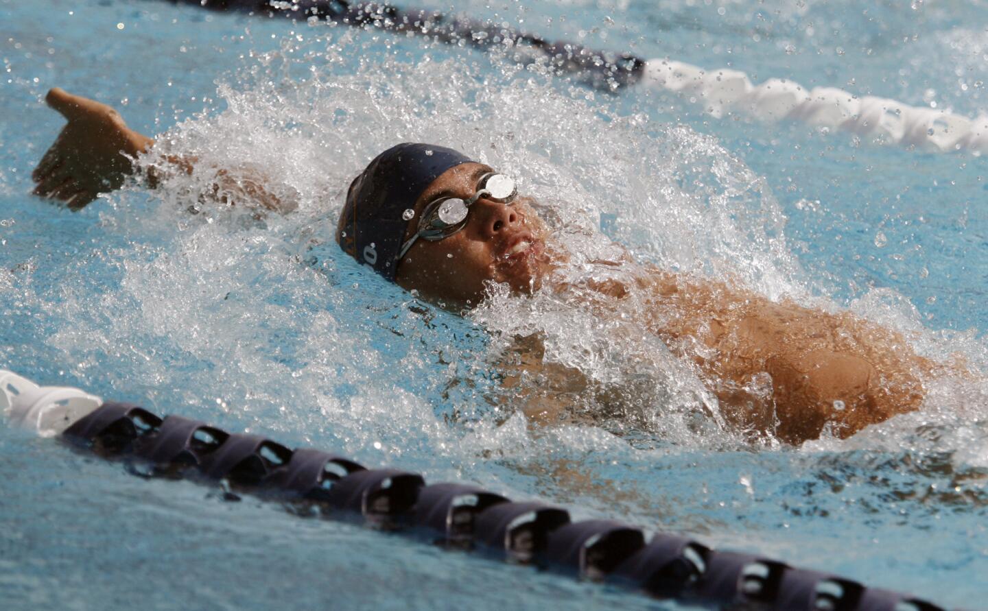 Pasadena Poly's Chandler Woo does a backstroke during a swim meet at Flintridge Prep in La Canada on Wednesday, April 11, 2012.