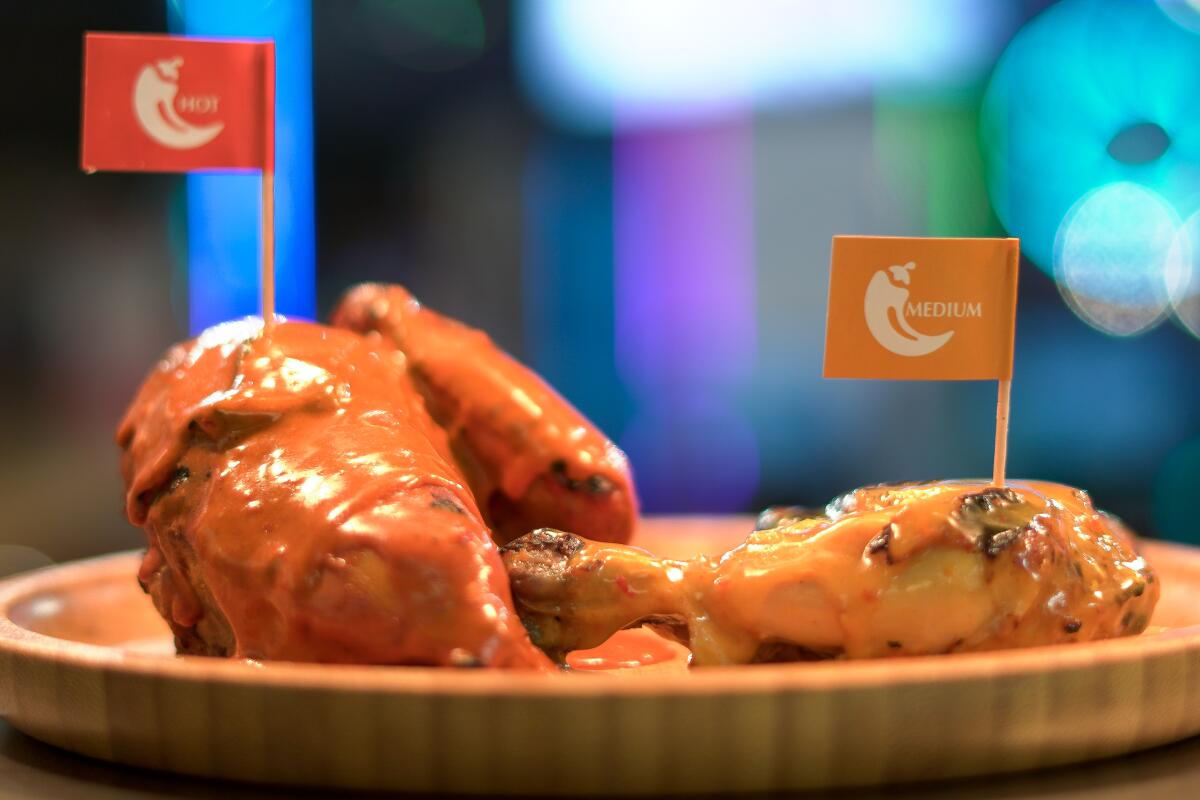 Peri-peri chicken with hot sauce at Tribos has paper flags stuck in the pieces to indicate spice levels.