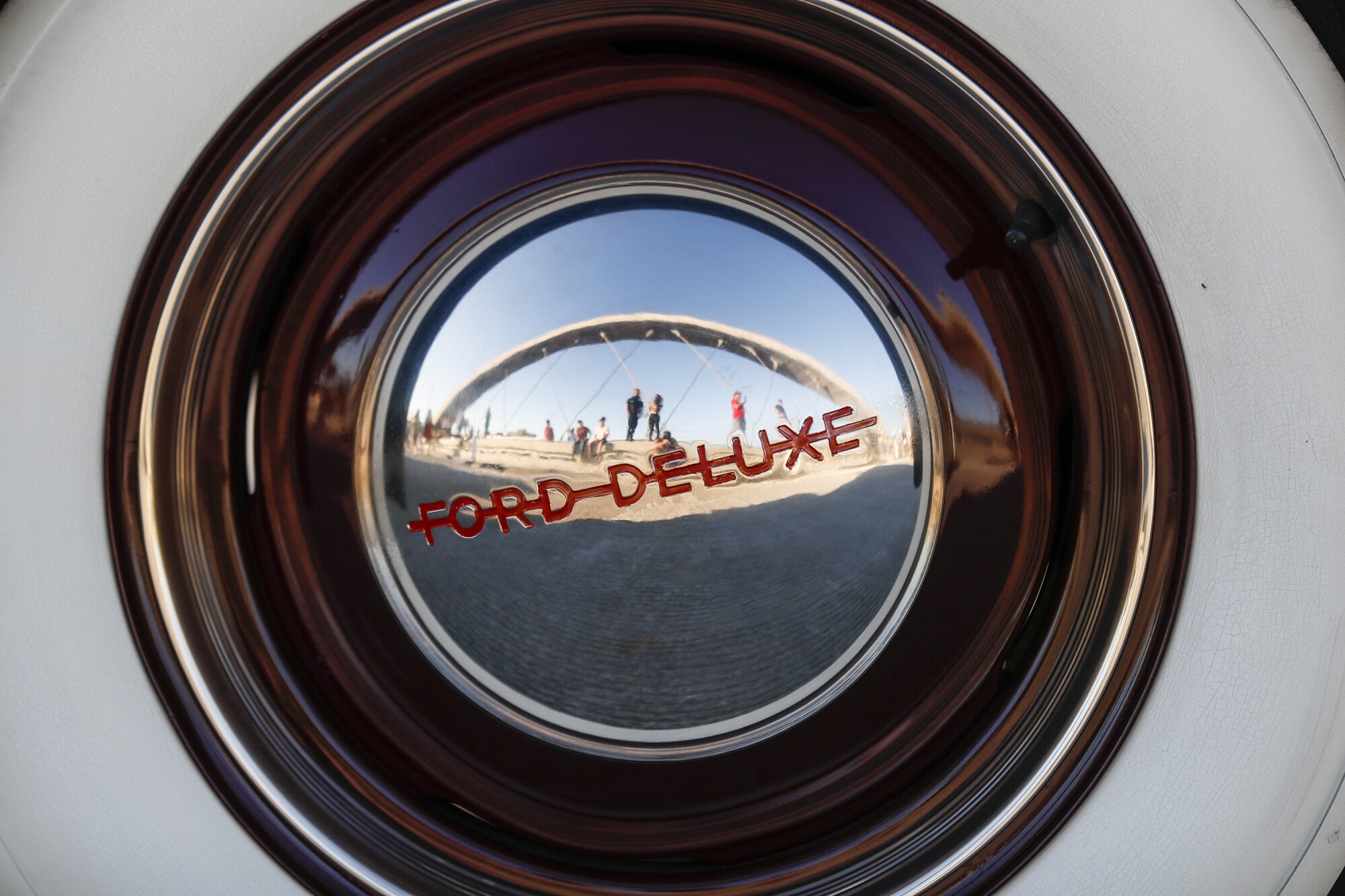 An arch on the 6th Street Viaduct is reflected in the hubcap of a lowrider.