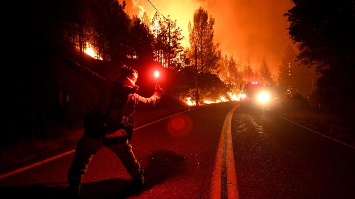 Cal firefighter Tyler Benson throws a flare to start a back fire as the the Delta Fire burns along Pollard Camp Road north of Redding, California.