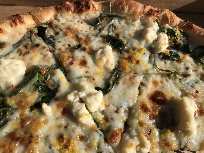 Bird Rock’s Wheat & Water’s wood-fired spinach and ricotta pizza gets an unexpected, and delicious, kick from lemon zest.