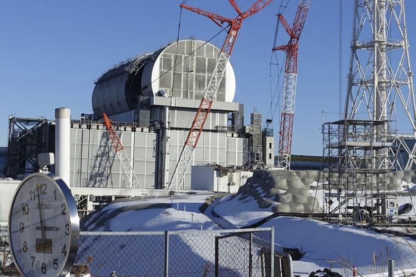 FILE - In this Jan. 25, 2018, file photo, an installation of a dome-shaped rooftop cover housing key equipment is near completion at Unit 3 reactor of the Fukushima Dai-ich nuclear power plant ahead of a fuel removal from its storage pool in Okuma, Fukushima Prefecture, northeast Japan. Tokyo Electric Power Co. said Monday, April 18, 2019, workers started removing the first of 566 fuel units stored in the pool at Unit 3. The fuel units in the pool are not enclosed and their removal to safer ground is crucial to avoid disaster in case of another major quake. (AP Photo/Mari Yamaguchi, File)