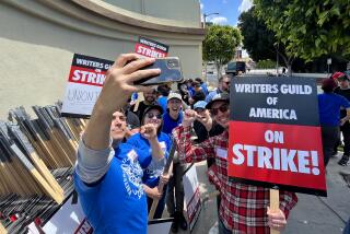 Los Angeles, CA - May 02: WGA members take a selfie before heading to the picket line on the first day of their strike in front of Paramount Studios in Hollywood on May 2, 2023. The union were unable to reach a last minute-accord with the major studios on a new three-year contract to replace one that expired Monday night. (Genaro Molina / Los Angeles Times)