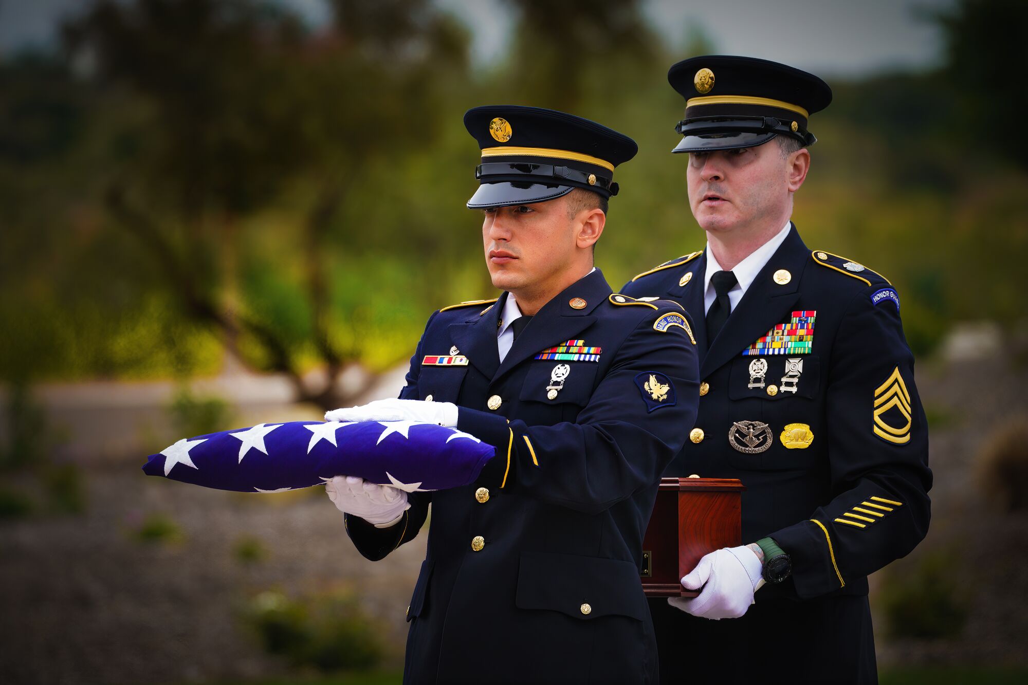 Honor Guard members carry a folded U.S. flag.