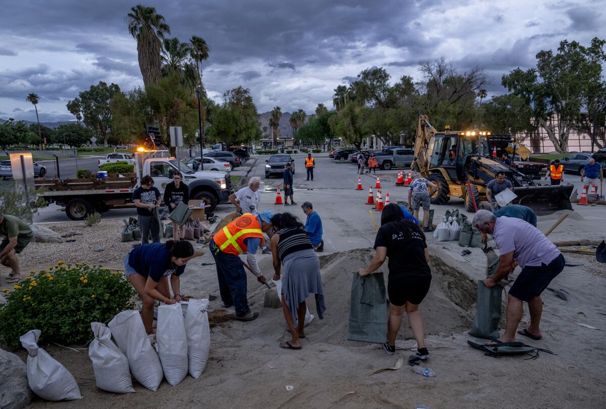 People fill sandbags under gathering clouds.