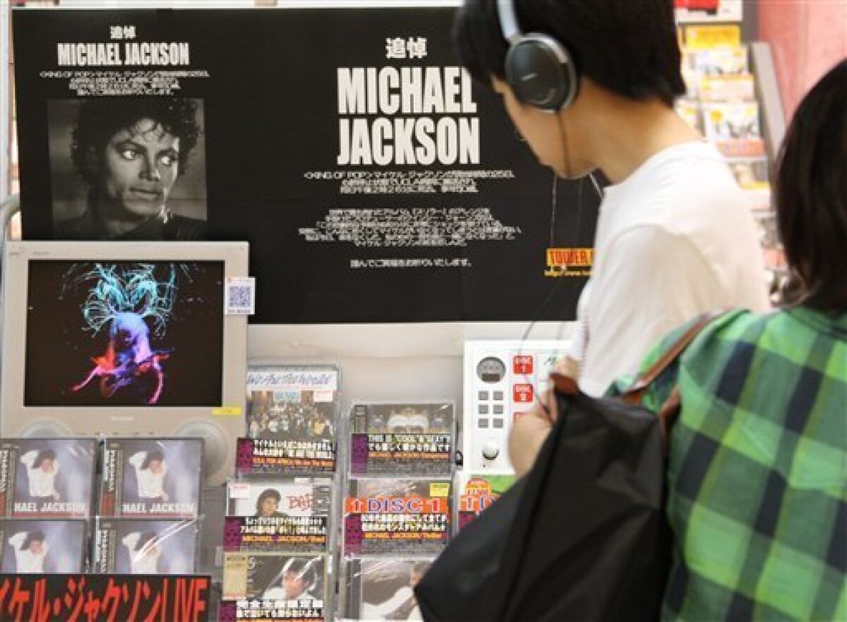 A man listens to Michael Jackson's CD in front of a specially set section in memory of the late superstar, showcasing his CDs, DVDs and videos, at a Tower Records Japan store in Tokyo, Japan, Friday, June 26, 2009. Japanese fans were always among Jackson's most passionate supporters, and news of his death Thursday in California came as a huge shock. (AP Photo/Koji Sasahara)