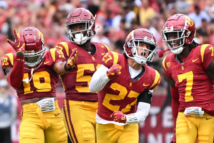 Los Angeles, California September 2, 2023-USC defenders from left, Jaylin Smith, Shane Lee, Bryson Shaw and Caleb Bullock celebrate a stop of a Nevada running back in the first quarter at the Coliseum Saturday. (Wally Skalij/Los Angles Times)