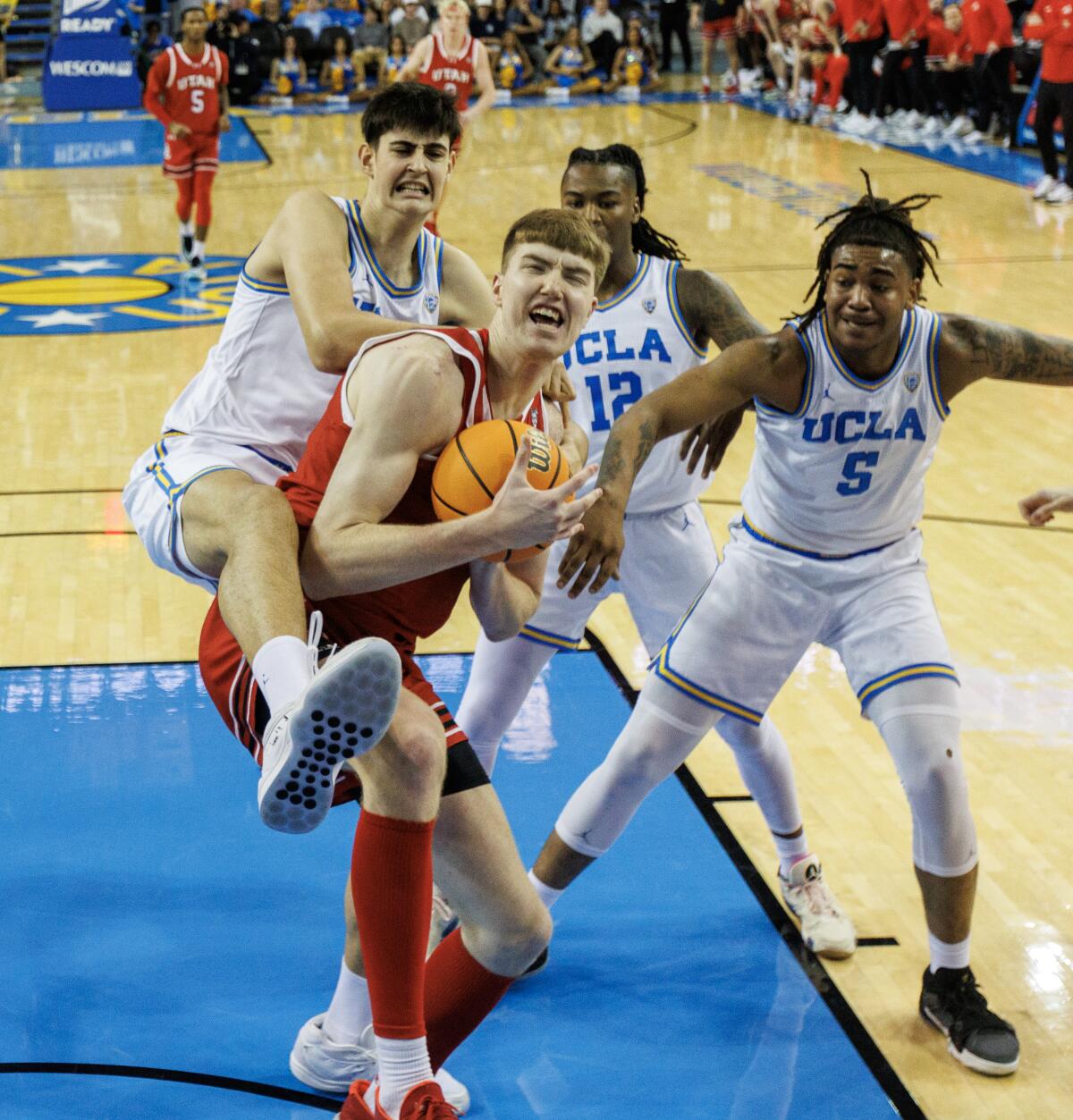 UCLA center Aday Mara climbs on the back of Utah center Lawson Lovering while battling for a rebound.