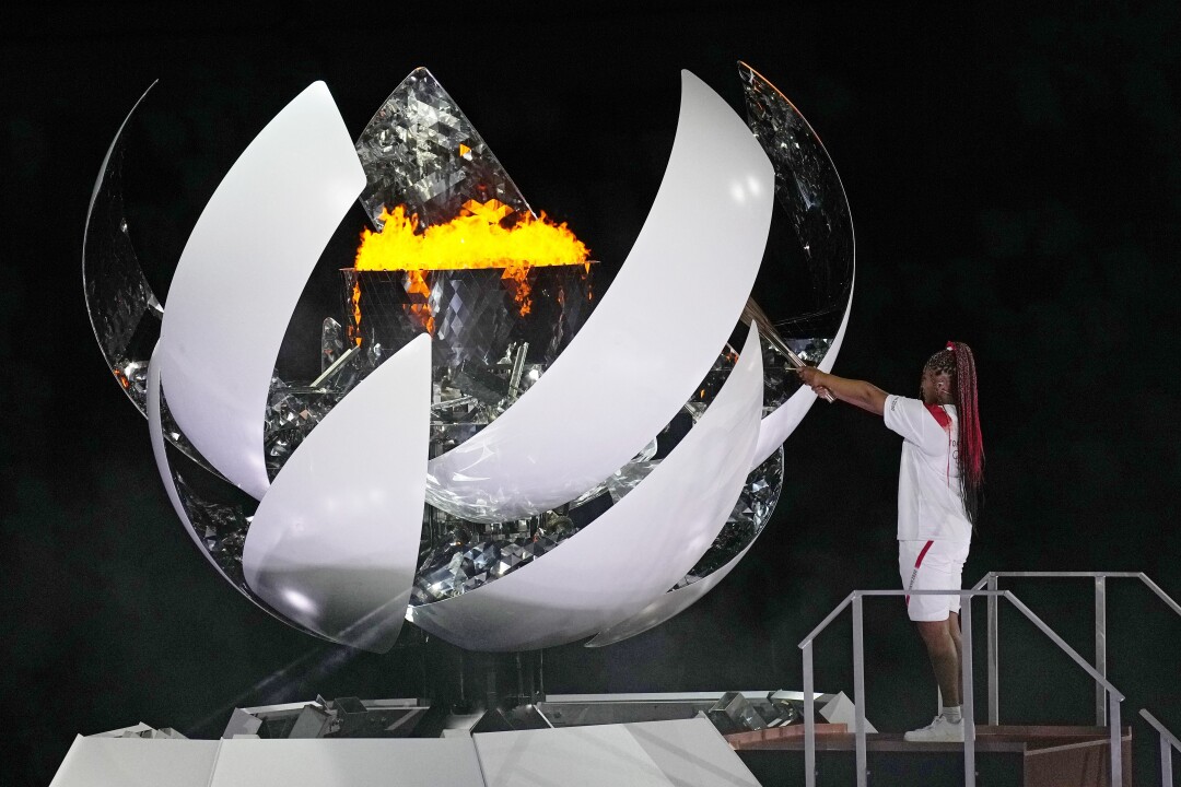 نائومی اوزاکا در مراسم افتتاحیه ورزشگاه المپیک شعله المپیک را روشن می کند.