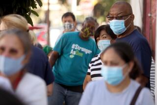 LOS ANGELES, CA - OCTOBER 15, 2020 - People wait in line to receive free food, provided by Food Bank, and a bag filled with Personal Protection Equipment (PPE), provided by the Office of Councilman Gil Cedillo, at the weekly food giveaway at Hope on Union in Los Angeles on October 15, 2020. PPE kits included face shields, masks, hand sanitizer, and gloves to help people prevent COVID-19. Food Bank has been providing food at the weekly giveaway for several months during the coronavirus pandemic. (Genaro Molina / Los Angeles Times)