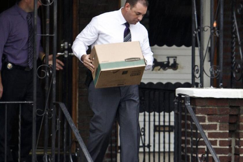 Investigators carry evidence from the home of Griffin Campbell in Philadelphia. Campbell's construction company was handling the demolition of a building last week when it collapsed into a neighboring store, killing six.