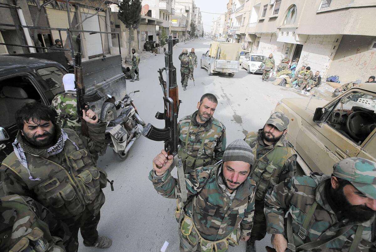 Pro-government forces stand on a street in the Syrian town of Yabroud. With Yabroud's capture, all the major towns along rebel supply lines from Lebanon are in government hands.