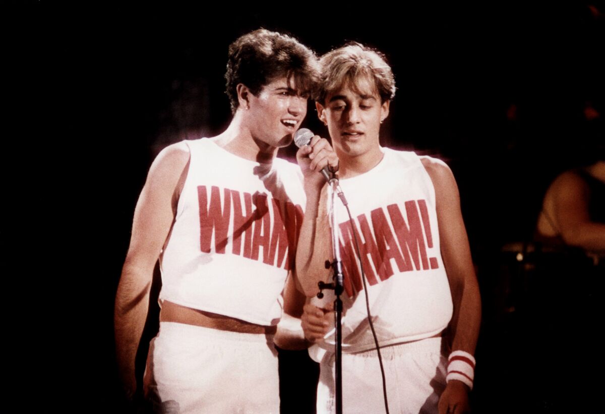 A music duo performs in matching t-shirts in the '80s