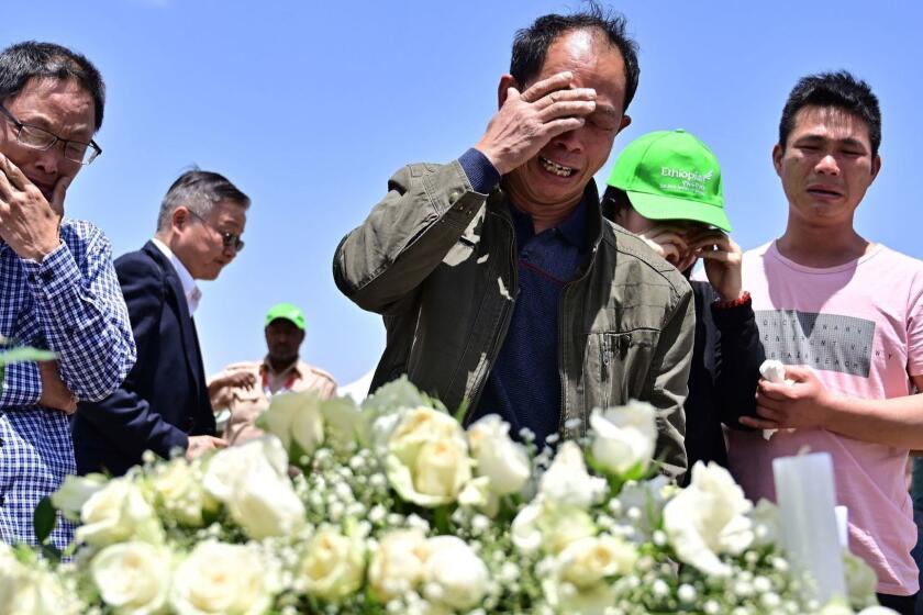 Family members mourn the victims at the crash site of the Ethiopian Airlines operated Boeing 737 MAX aircraft, at Hama Quntushele village in the Oromia region, on March 13, 2019. - A Nairobi-bound Ethiopian Airlines Boeing crashed minutes after takeoff from Addis Ababa on March 10, 2019, killing all eight crew and 149 passengers on board, including tourists, business travellers, and "at least a dozen" UN staff. Families of the victims were taken to the remote site on March 13, 2019, where the plane smashed into a field with 157 passengers and crew from 35 countries, leaving a deep black crater and tiny scraps of debris. (Photo by TONY KARUMBA / AFP)TONY KARUMBA/AFP/Getty Images ** OUTS - ELSENT, FPG, CM - OUTS * NM, PH, VA if sourced by CT, LA or MoD **