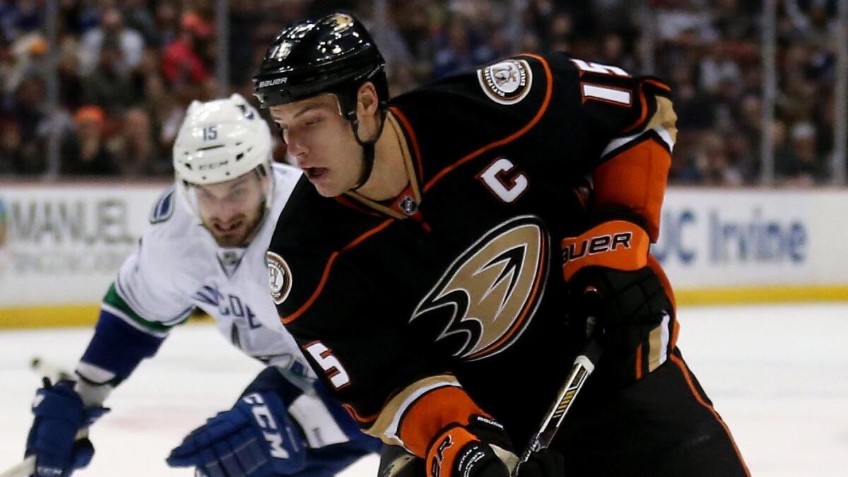 Ducks captain Ryan Getzlaf controls the puck in front of Vancouver Canucks forward Brad Richardson during a Ducks' win on Sunday.