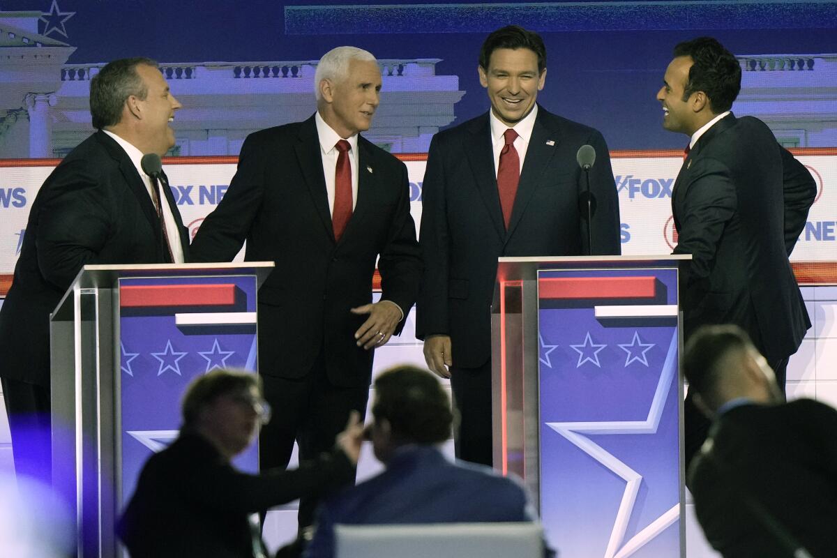 Republican presidential primary candidates talk during a break in an August debate.