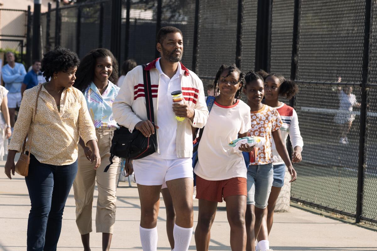 Several women walk with a man in a scene in the movie "King Richard"