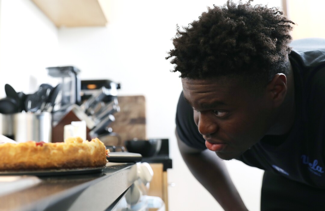 UCLA Defensive Lineman Otito Ogbonia nimmt einen Erdbeer-Käsekuchen in seiner Wohnung in der Nähe des Campus unter die Lupe 