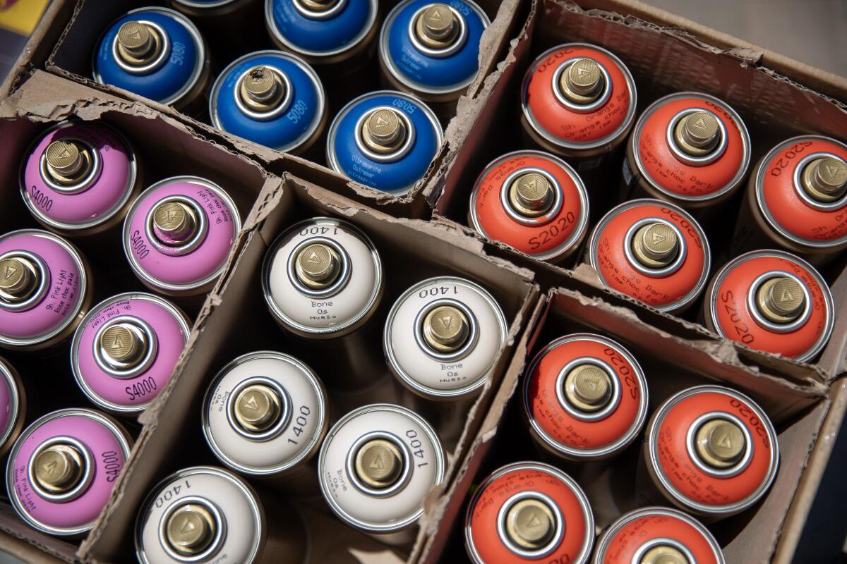 Spray-paint cans in a box